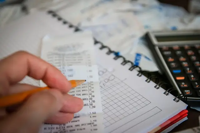 Pessoa organizando dinheiro e calculadora representando como economizar sem perder qualidade de vida
