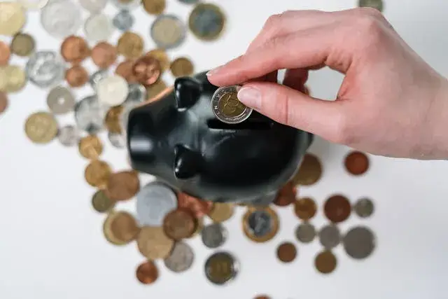 Cofre em formato de porquinho com moedas representando crescimento através de pequenos hábitos